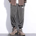 Men's grey ankle-tied straight leg sweatpants laid flat on a surface.