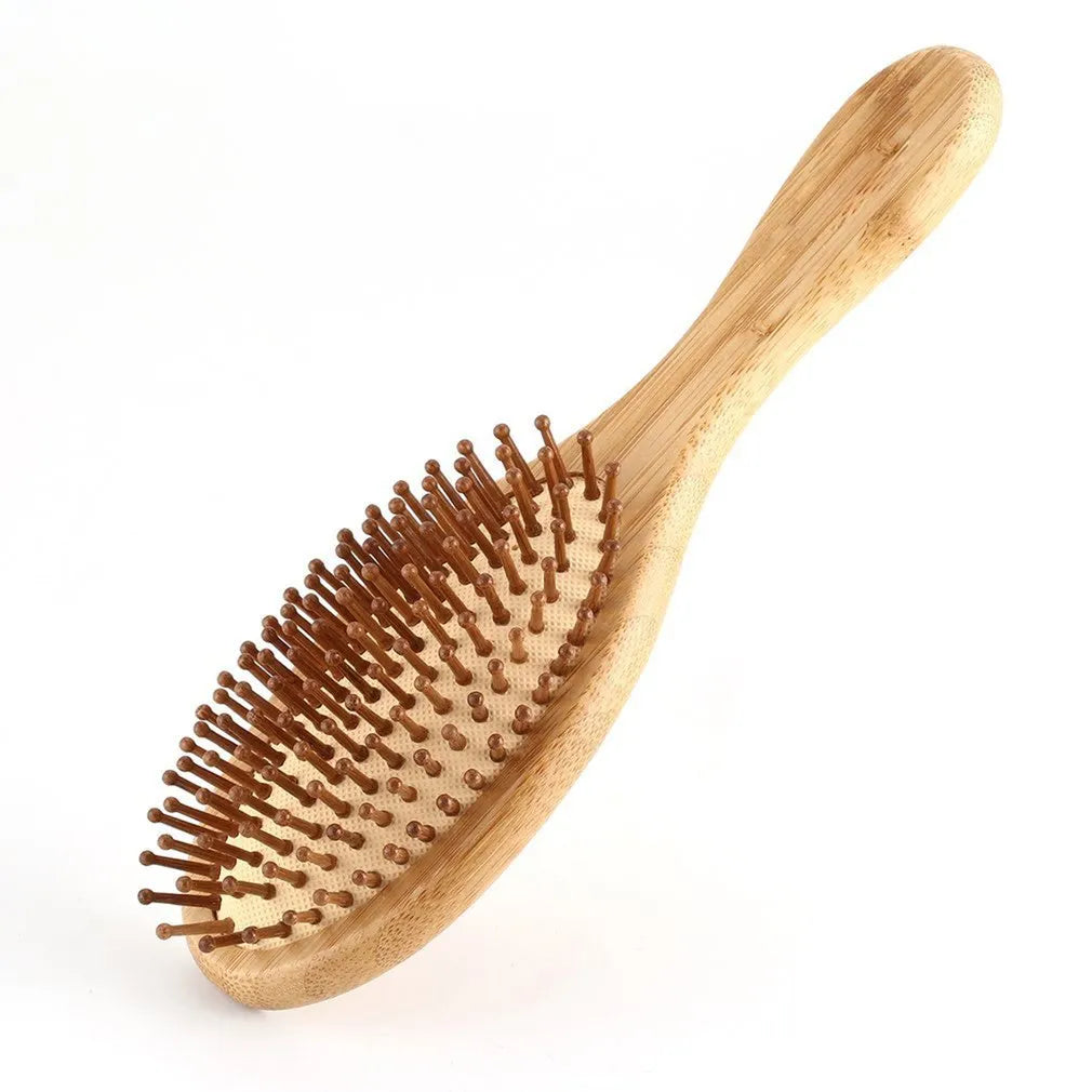 Carbonised bamboo massage comb 66x218mm on neutral background with smooth wooden surface visible