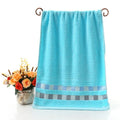 Cotton face towel 73x33cm in blue pink yellow patterns on hanger