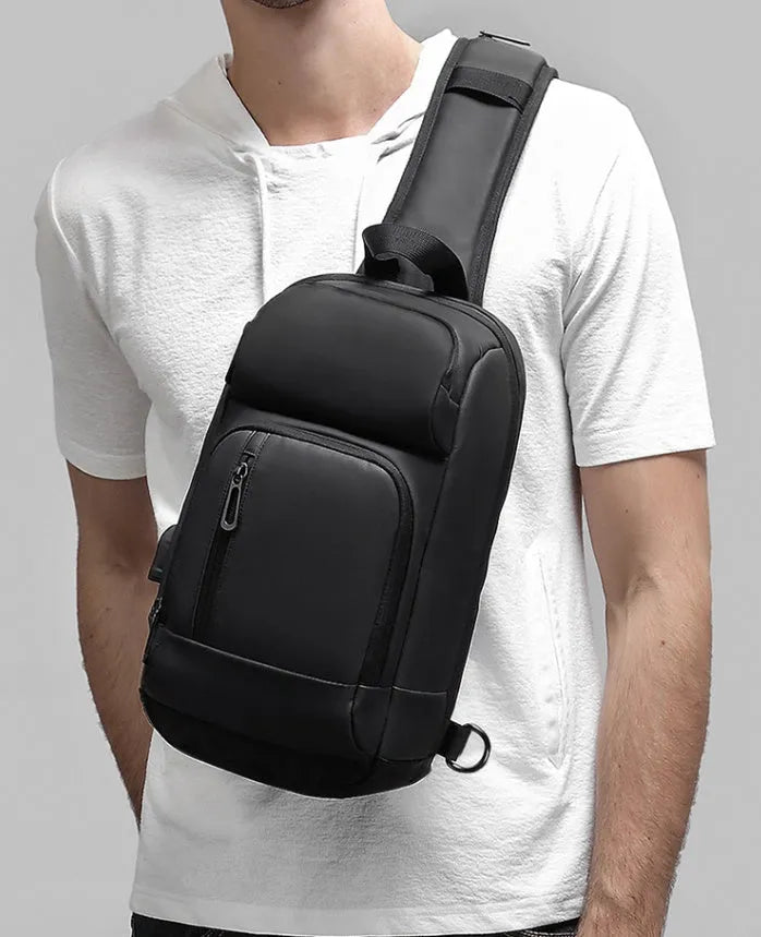 Black PVC outdoor shoulder bag showing medium size, shoulder strap, and internal pocket organisation