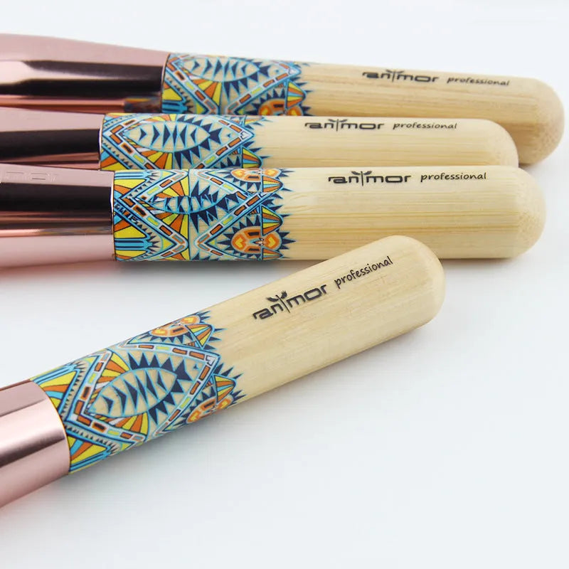 12 makeup brushes with man-made fibre bristles and wooden handles, arranged on a flat surface