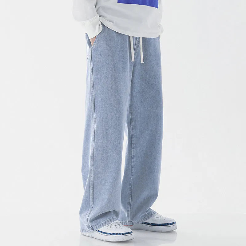 Mens fashion casual loose straight cotton denim jeans in retro light blue colour, full-length view