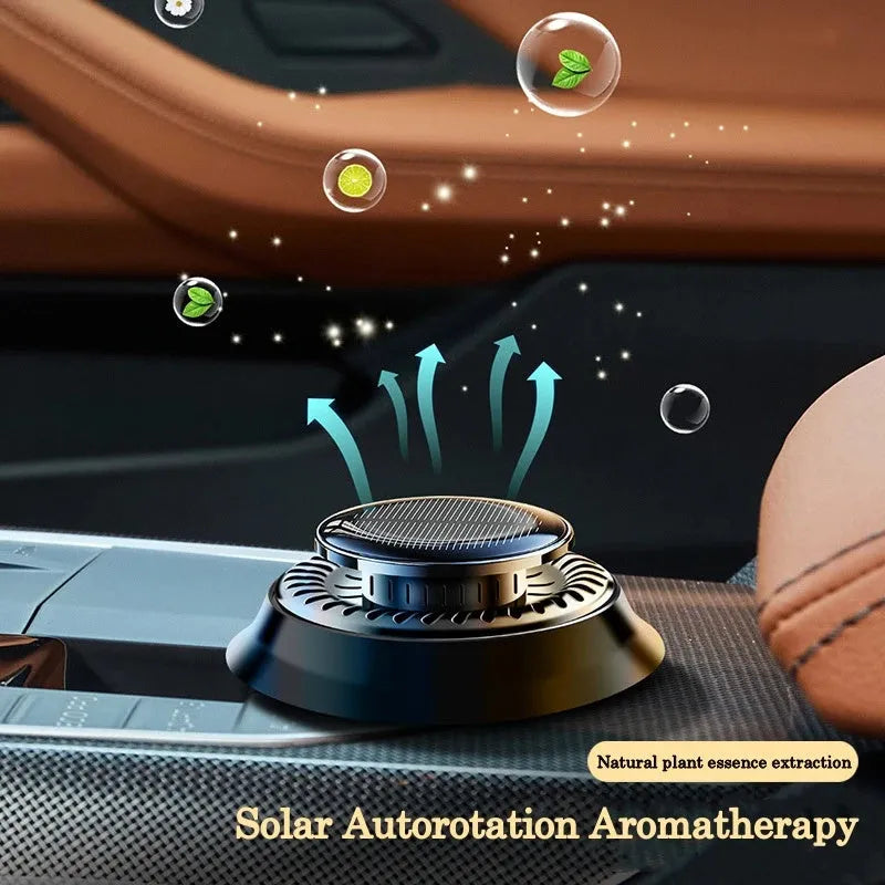 Black solar-powered kinetic double ring car air freshener diffuser on a car dashboard.