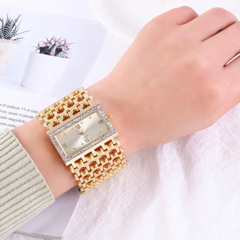 Women's steel band watch with square dial, Roman numerals, rhinestone details, and spiral crown in gold finish