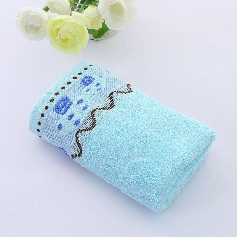 Cotton face towel 73x33cm in blue pink yellow patterns on hanger