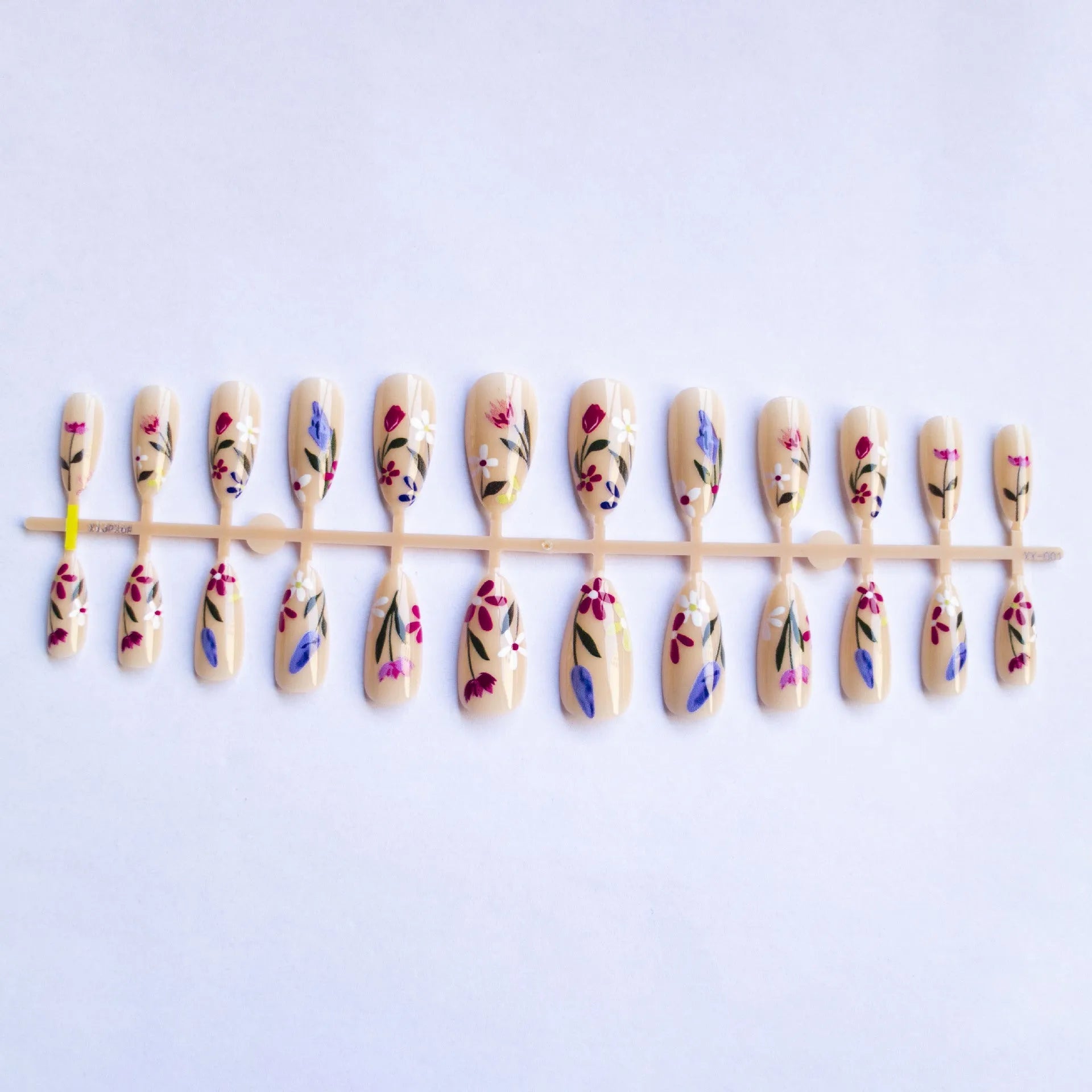 Almond-shaped false nails with detailed 3D pink rose and tulip floral designs on a solid colour base.