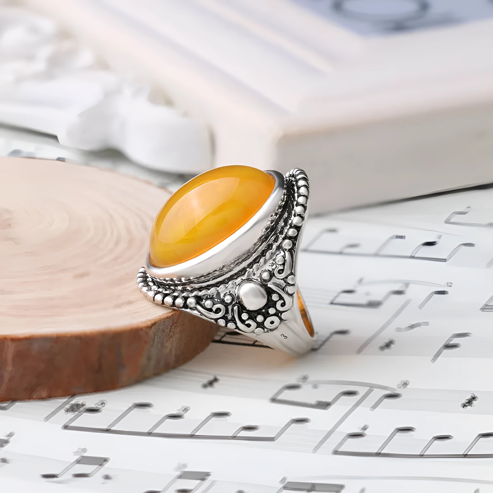 Geometric retro alloy ring in antique silver amber colour on a plain background.