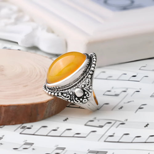 Geometric retro alloy ring in antique silver amber colour on a plain background.