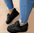 Womens white cotton slip-on shoes with round toe and non-slip rubber sole on a wooden floor.