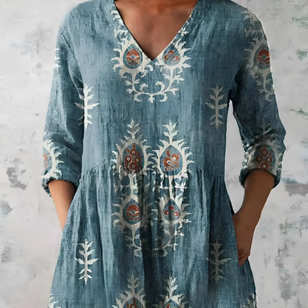 A woman wearing a loose-fitting printed dress with 3/4 sleeves and a wide waist.