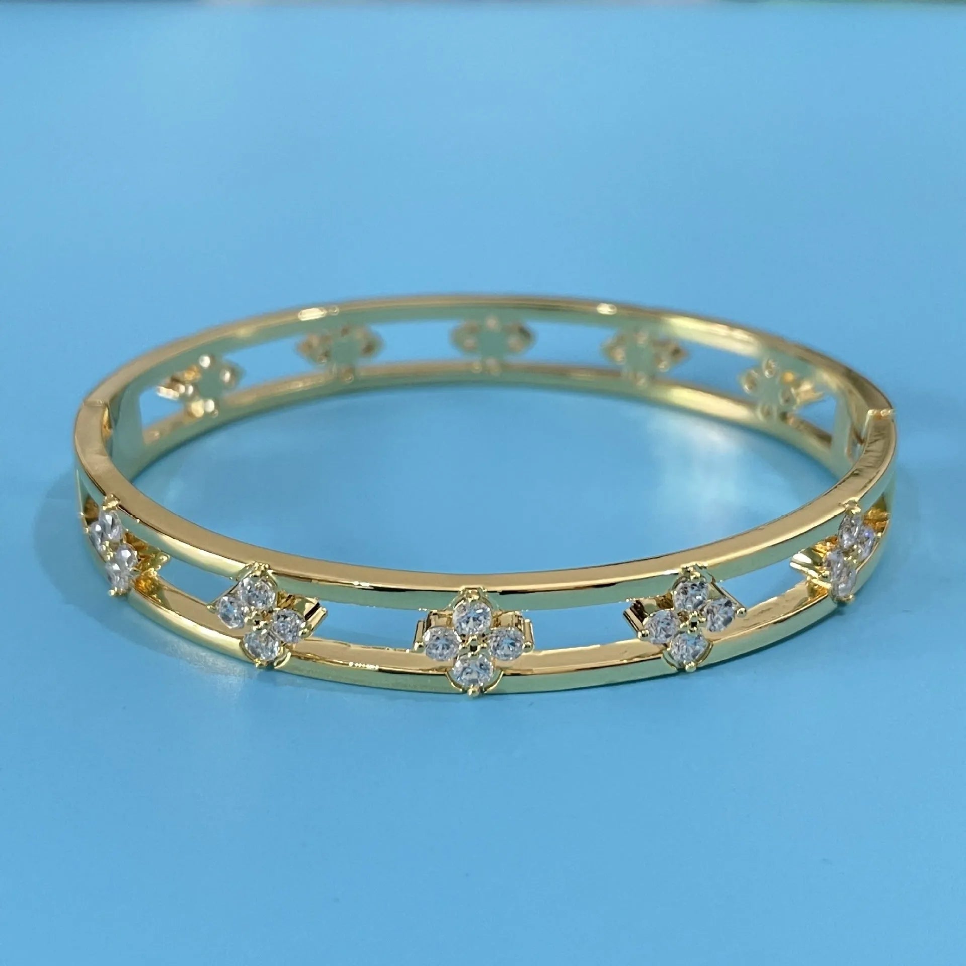 Gold or silver hollow women's bracelet with a four-leaf clover charm containing a white zircon stone.