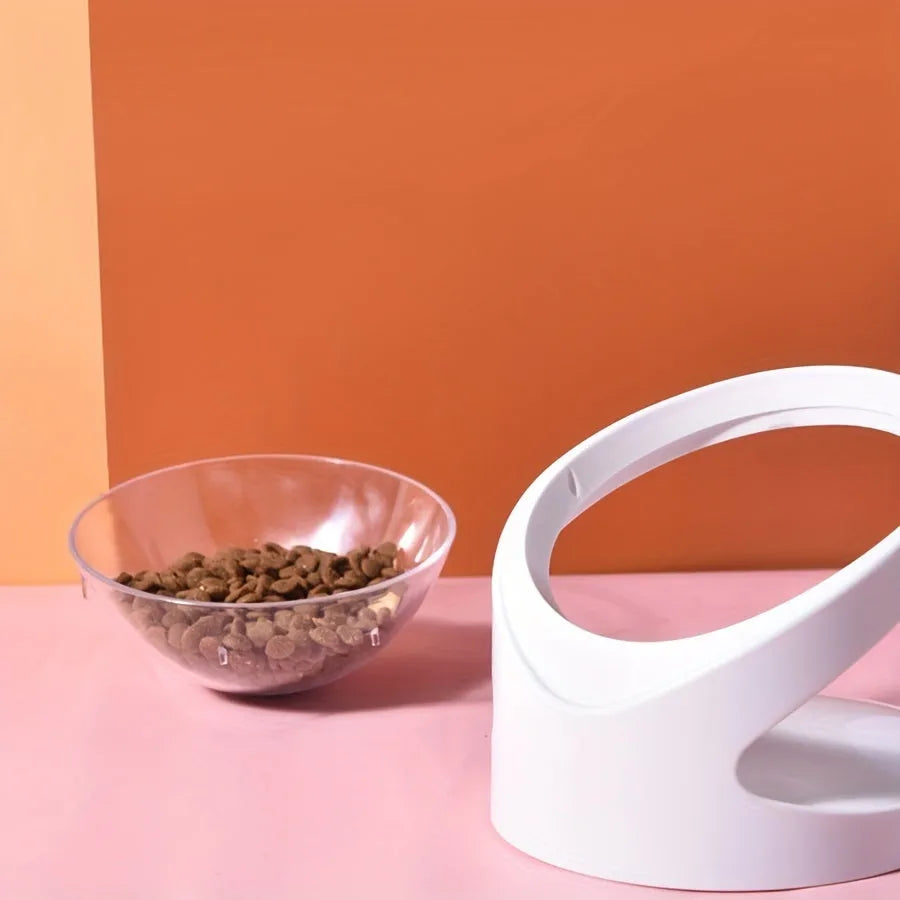 White clear plastic elevated cat food bowl with tilted anti-vomit design on a raised stand.