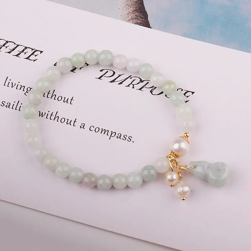 Emerald green jade bracelet with hand-carved gourd charm and pearl decoration in Chinese style