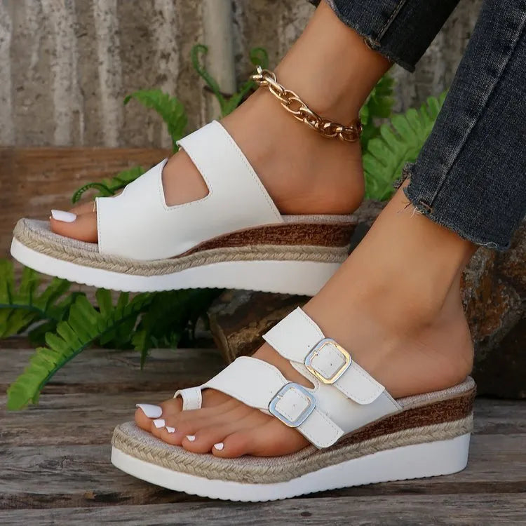 White patent leather wedge sandals with peep toe and woven design on model