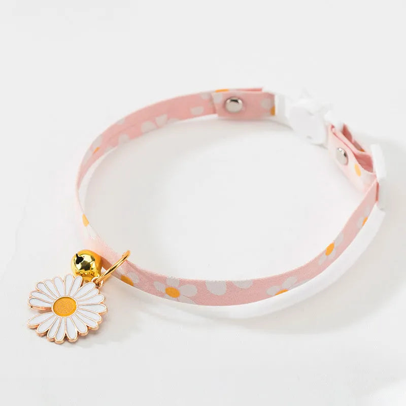 Green adjustable pet collar with a metal bell pendant and a matching bow tie on a white background.