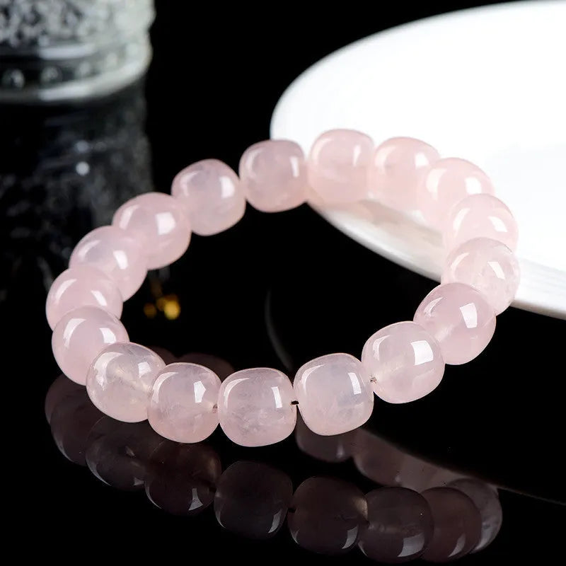 Pink crystal barrel bead bracelet with 11-12mm geometric beads on natural background