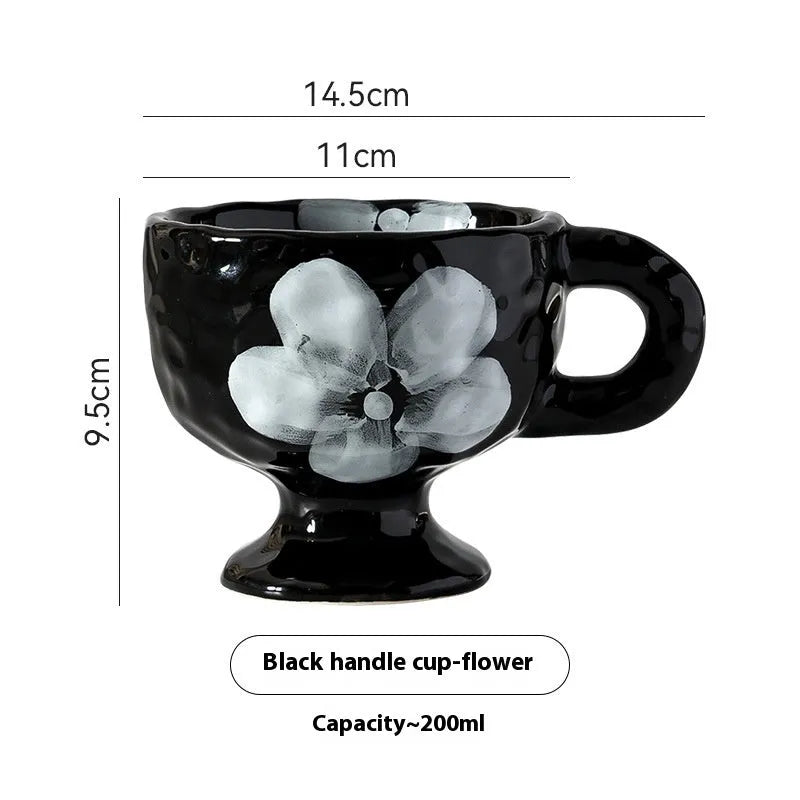 Hand-pinched irregularly shaped ceramic mug in a solid colour, shown on a table.