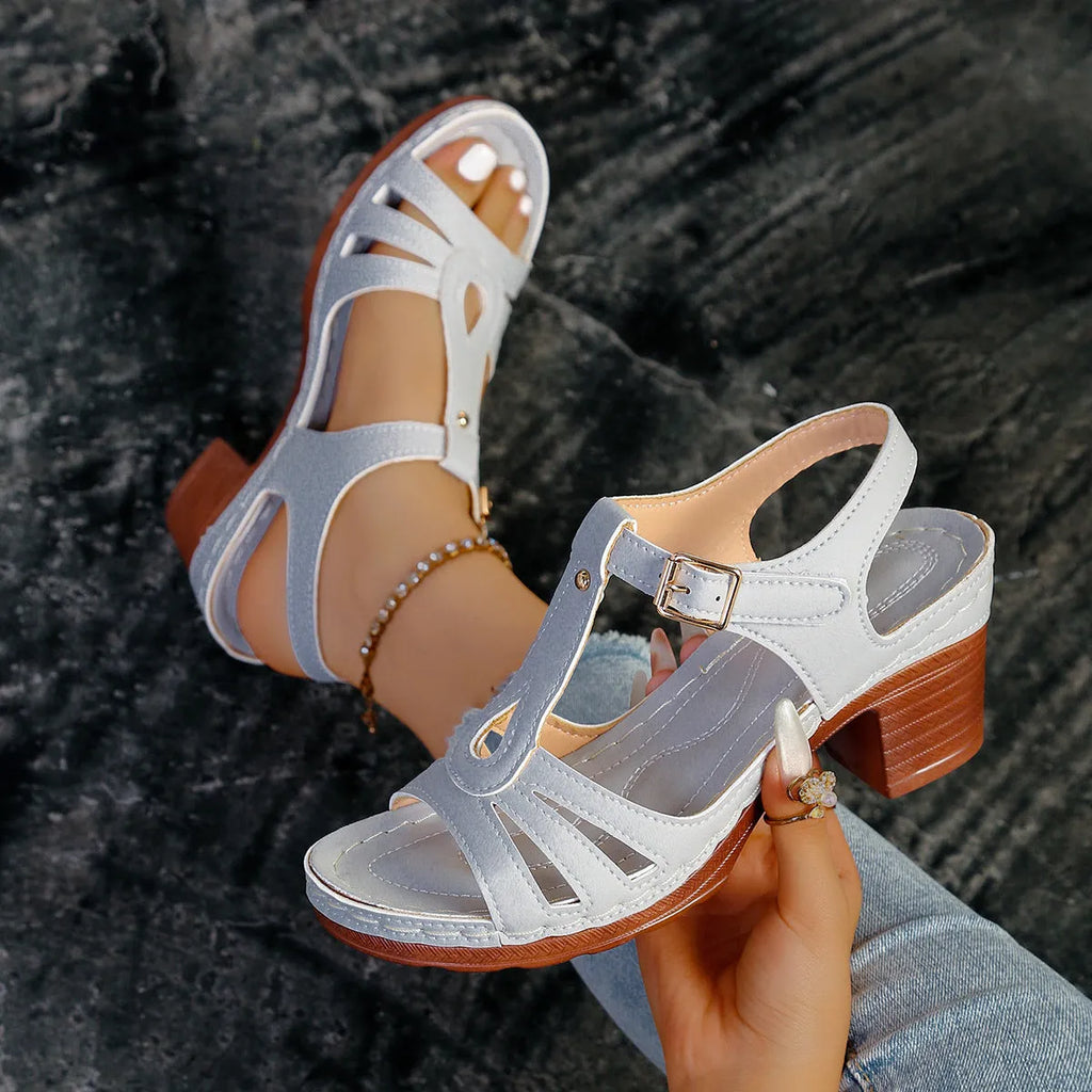 Women's black peep toe wedge platform sandals with a buckle fastening on a wooden surface.