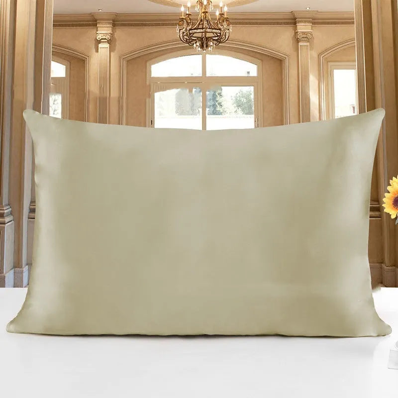 19 M double-sided silk pillowcase in apricot colour on a bed.