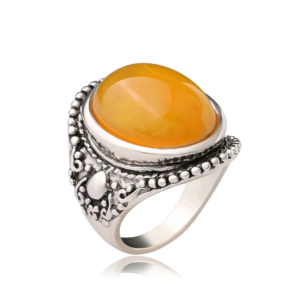 Geometric retro alloy ring in antique silver amber colour on a plain background.