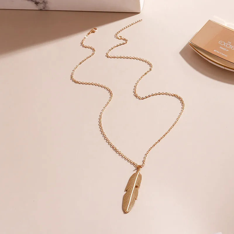 Retro feather tassel necklace for women in gold with geometric leaf pendant and feather tassel on alloy chain