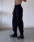 Men's plaid trousers with a full apron panel attached to the front, in a tartan pattern.