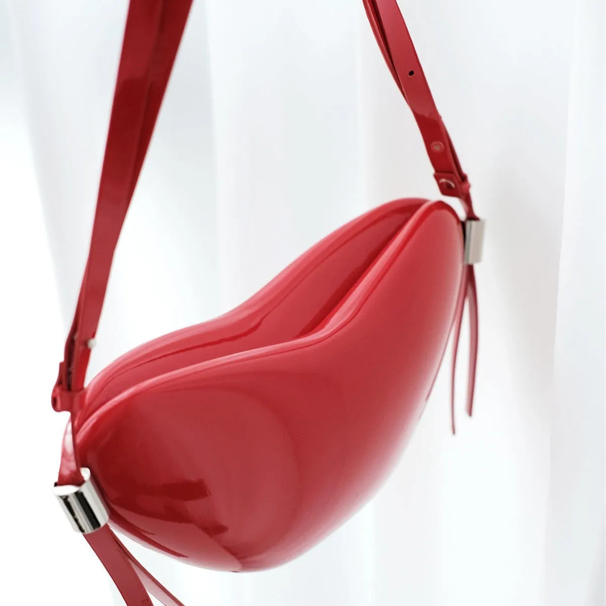 Red heart-shaped crossbody bag in PU material with single shoulder strap and exterior pocket