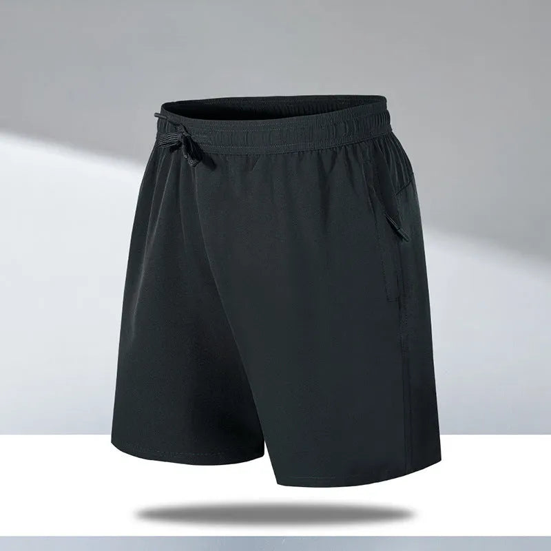 Man wearing loose-fit black quick-drying polyester beach shorts with a micro-elastic waistband.