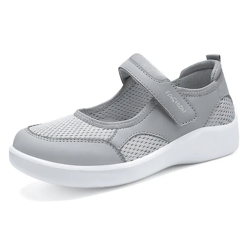 Women's low-top grey mesh sneakers with Velcro straps on a flat polyurethane sole.