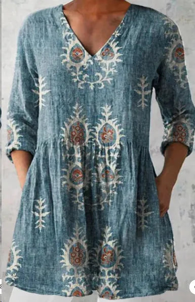 A woman wearing a loose-fitting printed dress with 3/4 sleeves and a wide waist.