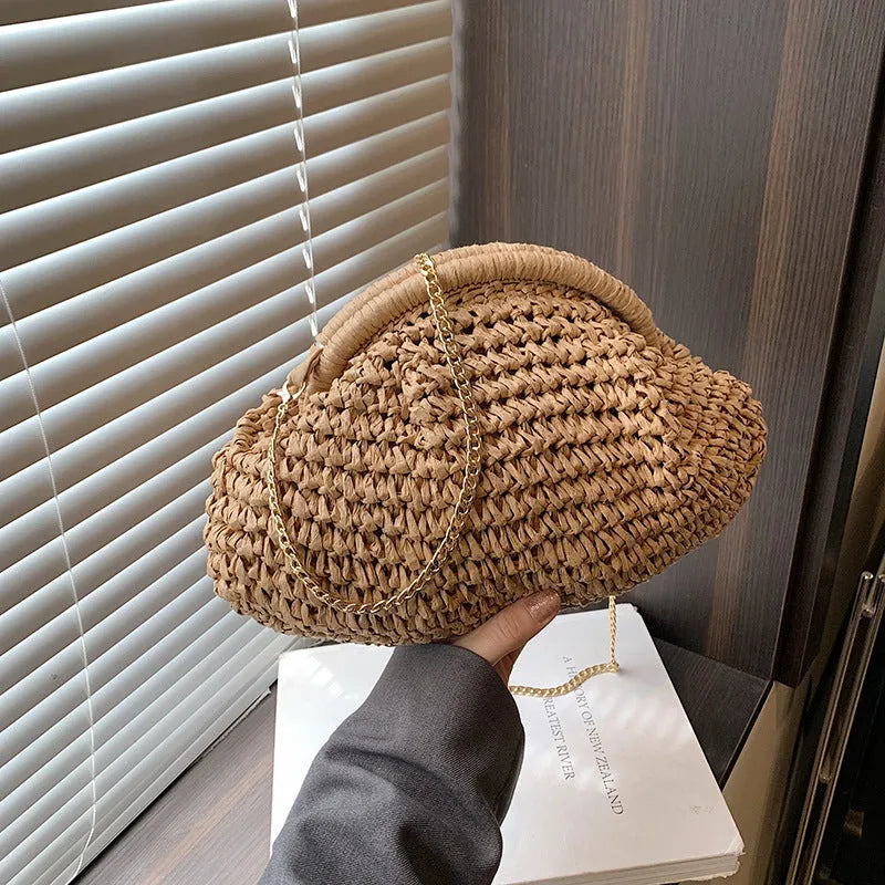 Women's khaki paper straw shoulder bag with chain strap and shell shape showing internal zippered compartment