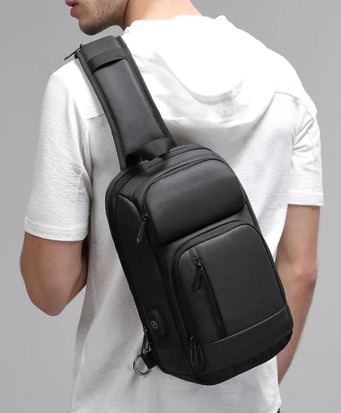 Black PVC outdoor shoulder bag showing medium size, shoulder strap, and internal pocket organisation