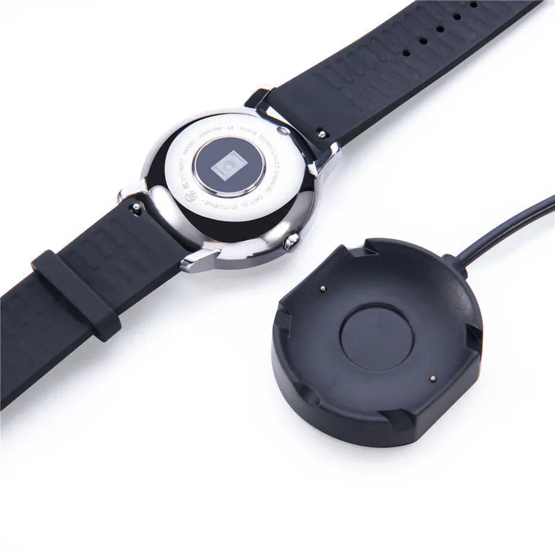 Black Withings Hybrid Smart Watch charging cable with magnetic probe on a desk