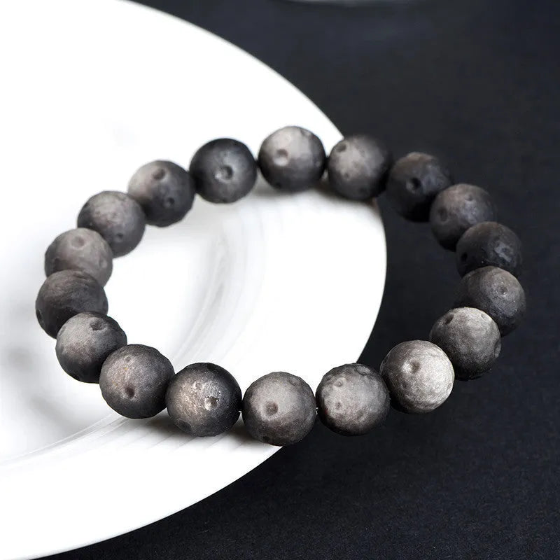 Natural obsidian crater ball bracelet with polished beads in silver or golden meteorite colours