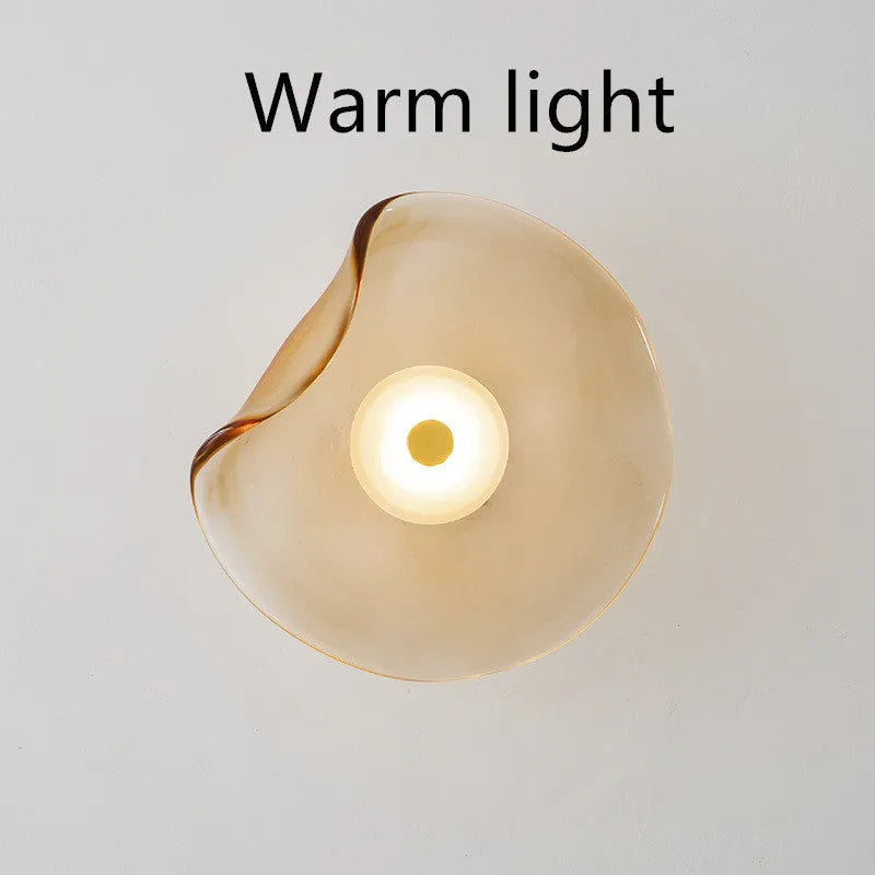 Round glass bedside wall lamp in cognac, light purple, or smoky grey colour.