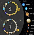 Set of two natural stone beaded bracelets with Zodiac sign charms on a dark background.