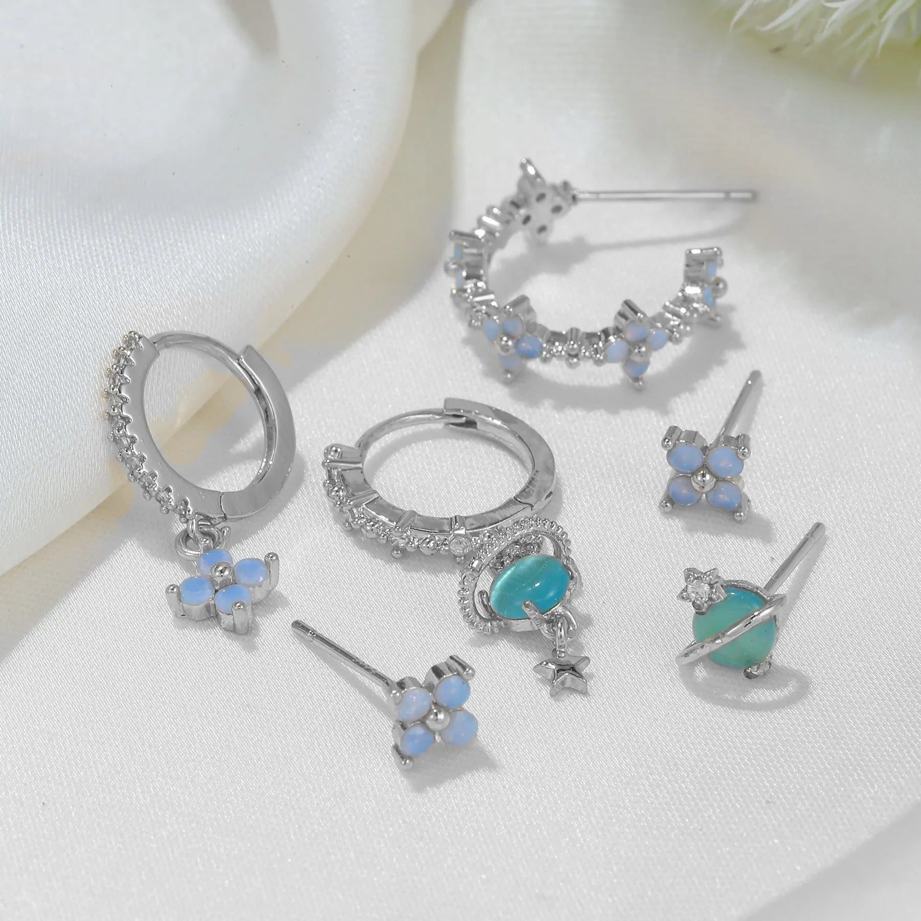 Flower-shaped stud earrings with zircon crystal centres in gold and silver colour options