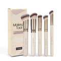 MAANGE five apricot coloured makeup brushes with angled blush brush on pink surface