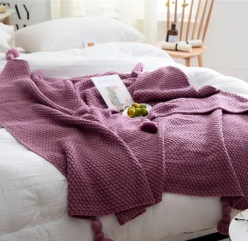 Fringed acrylic knit ball blanket 130x170cm in beige on a sofa
