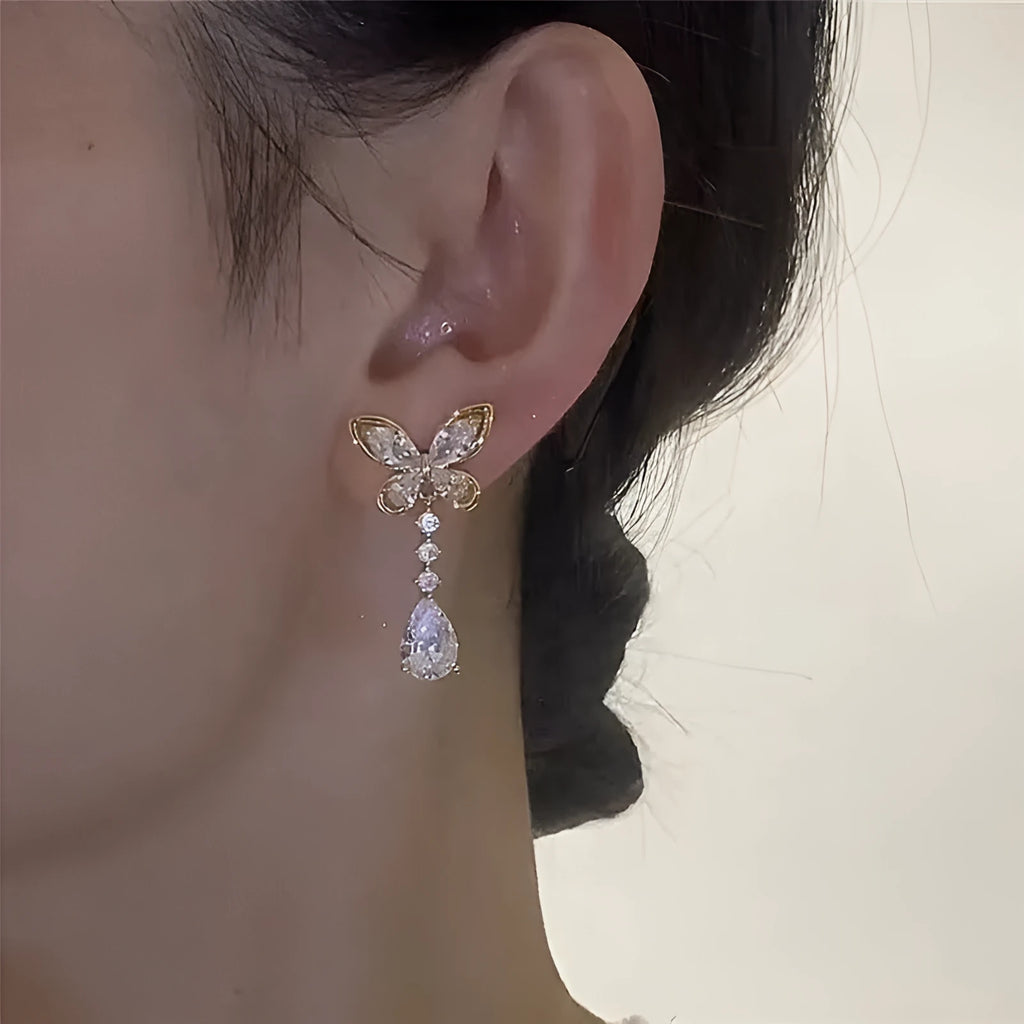 A pair of platinum-coloured bow-shaped stud earrings on a zinc alloy base.