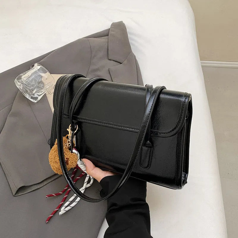 Brown women's Maillard-style PU leather shoulder bag with a double strap and a removable pendant accessory.