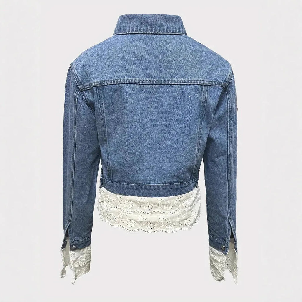 Blue women's denim jacket with decorative lace stitching on the front and sleeves.