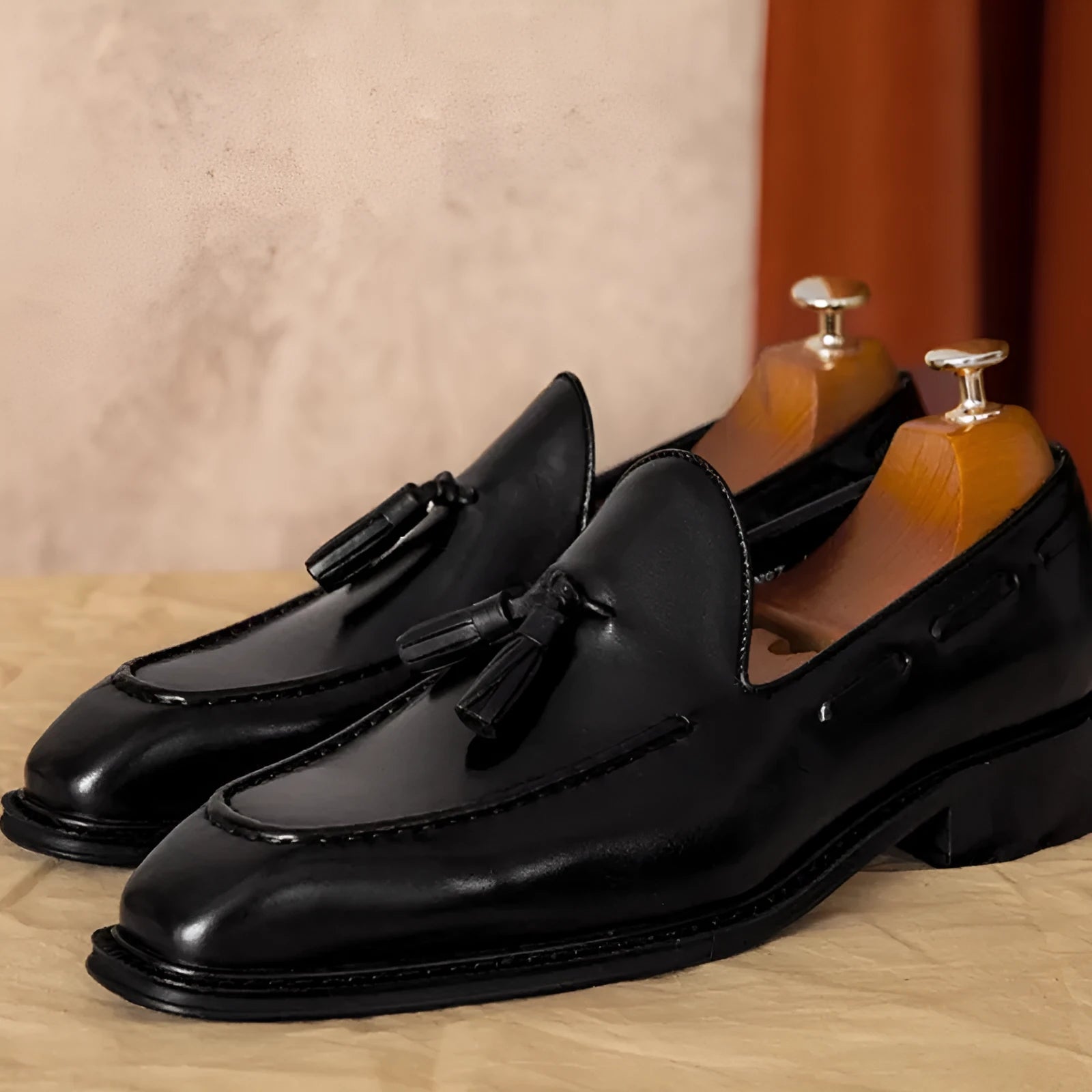Men's black and brown genuine leather slip-on loafers with a polished finish and rubber sole.