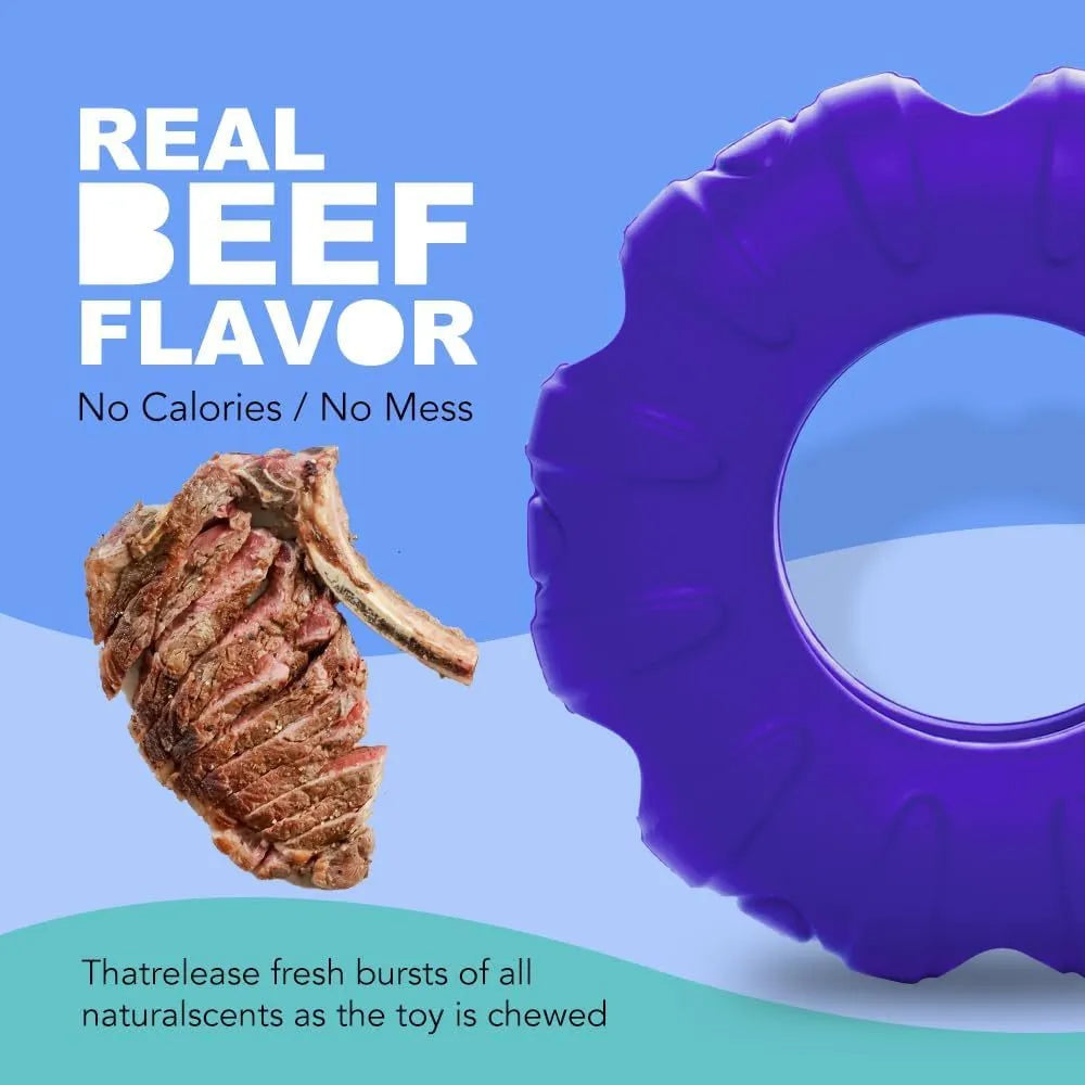 Blue tyre-shaped dog chew toy with oval openings for treat dispensing on a wooden floor.