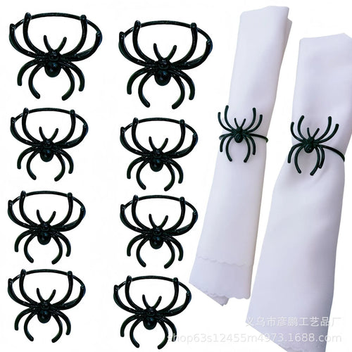 Six black metal spider-shaped napkin rings for Halloween table decoration.