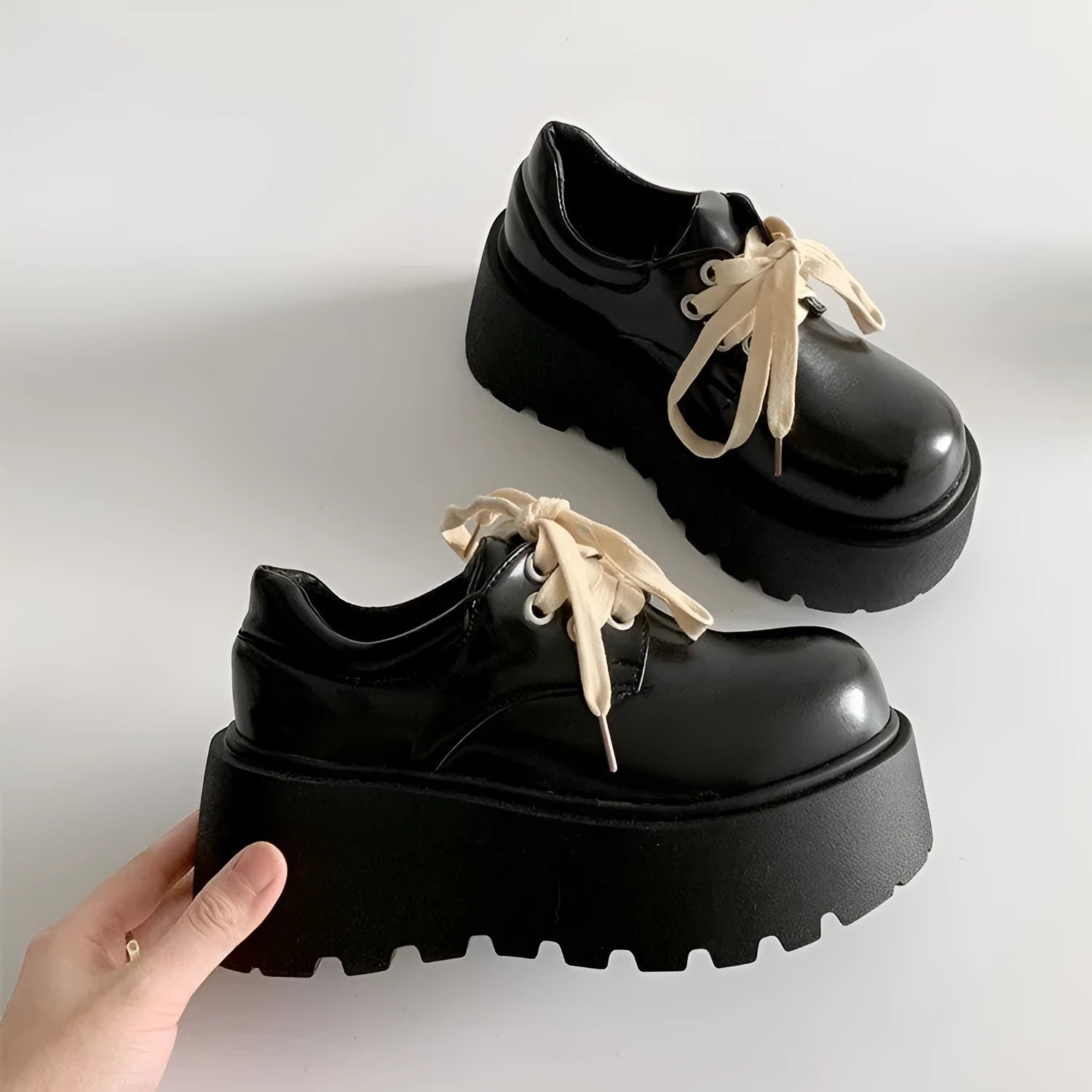 Women's matte black lace-up shoes with a high muffin heel and thick rubber sole.