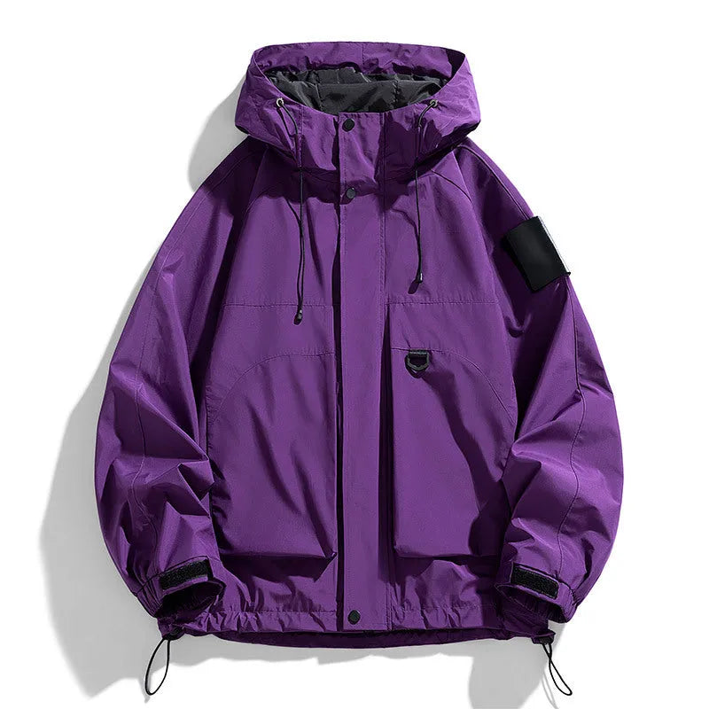 Man wearing a black hooded windproof waterproof jacket with long sleeves.