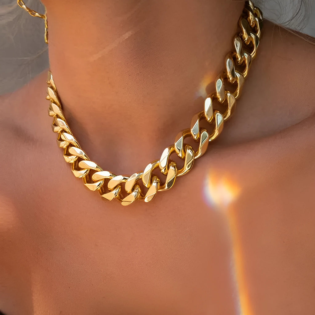 Women's gold thick chain necklace with a pendant on a model, showing its 32cm length.