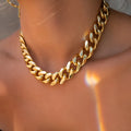 Women's gold thick chain necklace with a pendant on a model, showing its 32cm length.