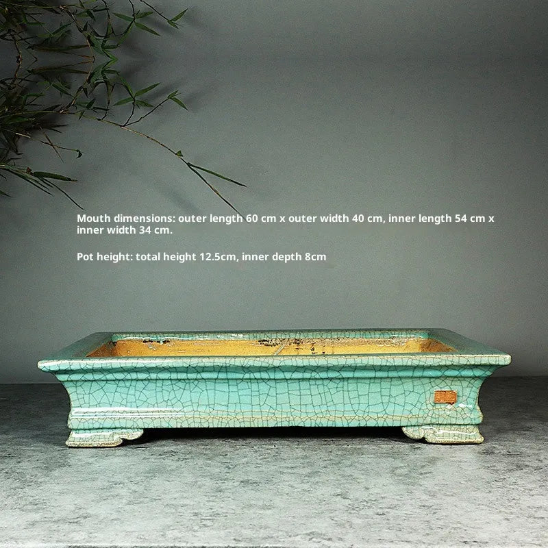 White cracked ceramic bonsai flowerpot with bamboo plant, manual purple sand craft